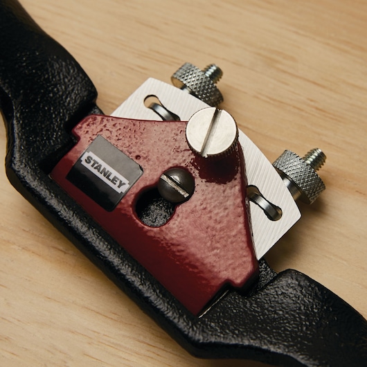 Photo of STANLEY 12-951 spokeshave tool with red and black body on wood surface.