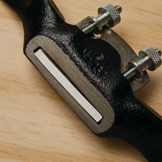 STANLEY 12-951 spokeshave tool, close-up of metal blade and adjustment screws on wood surface.