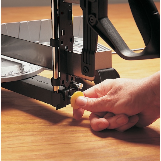 STANLEY 20-800 miter box saw close-up with hand adjusting yellow knob, tool on wooden surface.