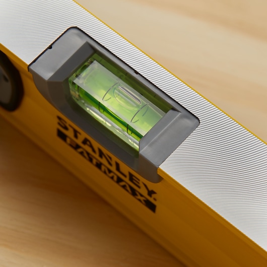 STANLEY 43-572 yellow spirit level close-up showing horizontal vial and rubber end cap.