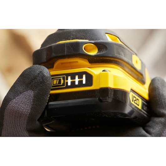 STANLEY SBI810D2K-B3 cordless tool battery close-up showing charge indicator, held by gloved hand.