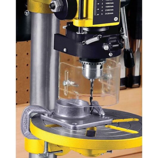 STANLEY SBT2513-B3 bench drill press close-up showing metal base, adjustable clamp, and safety shield.