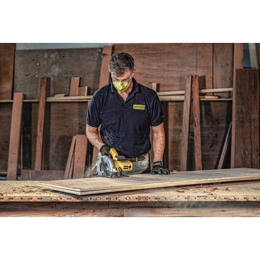 Stanley SC16 circular saw in use on wood in workshop, operator wearing Stanley shirt.