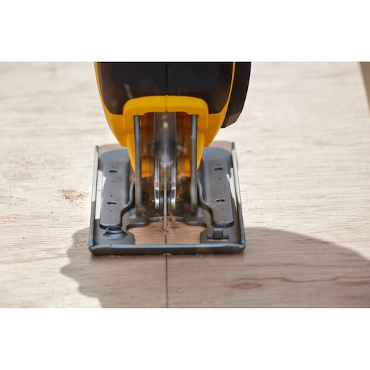 Stanley SCJ600B jigsaw cutting plywood, close-up front angle, yellow and black tool.