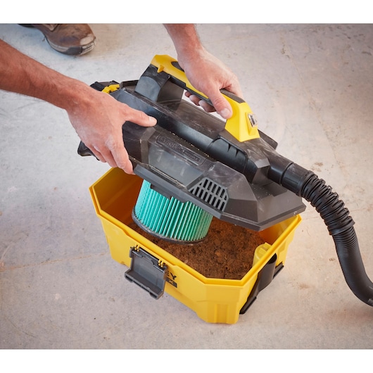 STANLEY SCV002 portable vacuum opened showing green filter and yellow base with dirt, top view.