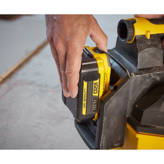 STANLEY SCV002 battery being inserted into a yellow and black power tool, close-up side angle.