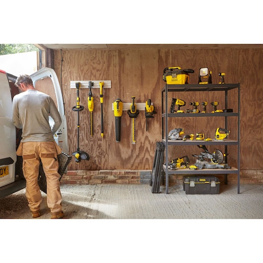 STANLEY SCV002 photography of yellow and black power tools organized on shelves and wall in a workshop.