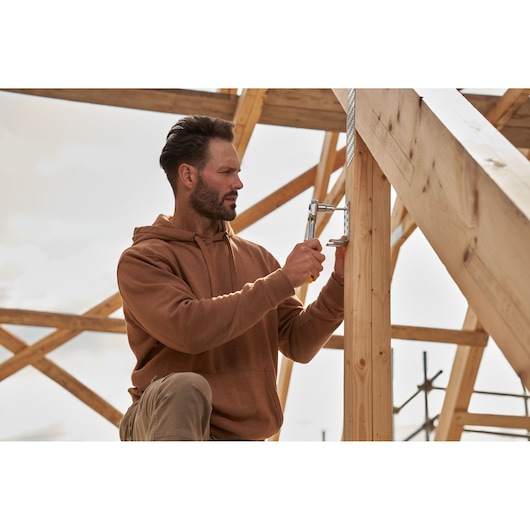 STANLEY STMT82832-1 ratchet wrench used for construction assembly on wooden frame, outdoor setting.