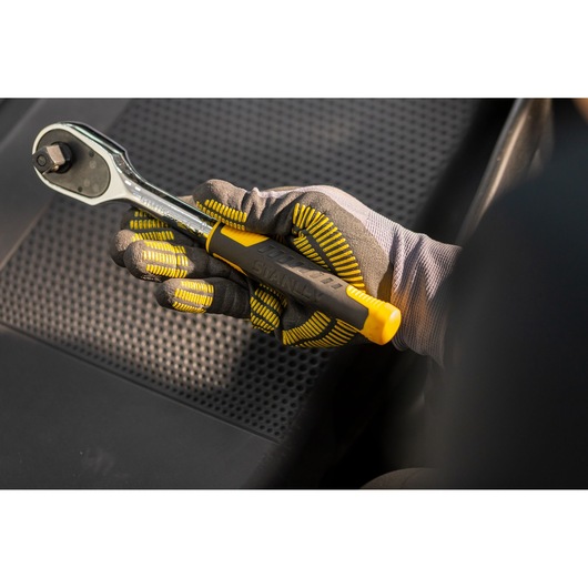 STANLEY STMT82832-1 ratchet wrench with yellow handle held by gloved hand on black car seat.