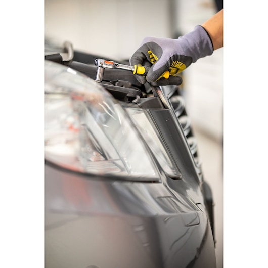 Photo of STANLEY STMT82832-1 ratchet being used to tighten a bolt on a car headlight, product in use.