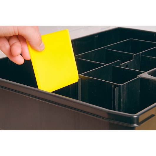 STANLEY STST14026 organizer box, close-up of hand inserting yellow divider, photography on white background.