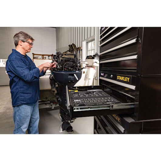 STANLEY STST22753BK tool chest with open drawer, organized hand tools, black finish, shown in workshop setting.