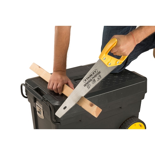 STANLEY stst33027__4_ hand saw cutting wood on black toolbox, side angle, photography product.