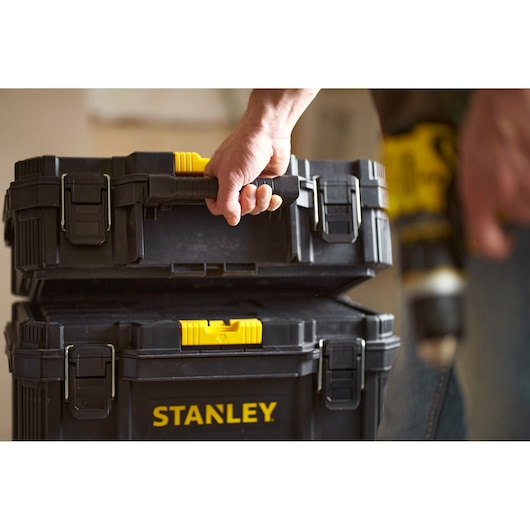 Photo of STANLEY STST83319-1 black and yellow stackable toolboxes being carried by a handle.