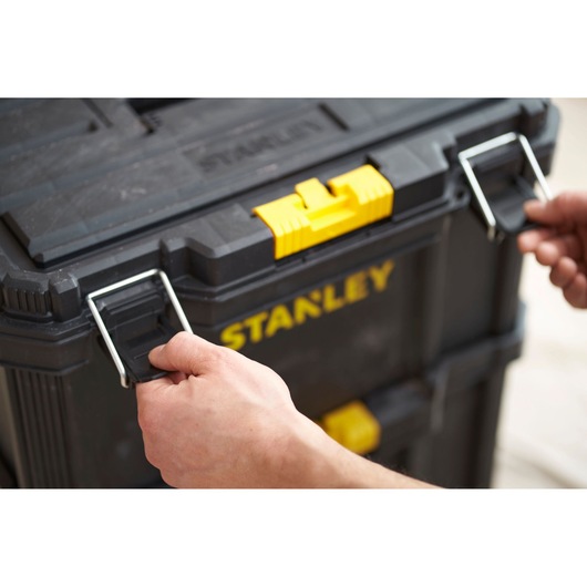 Stanley STST83319-1 black tool box with yellow latch being opened, close-up photography.