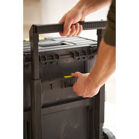 Photo of STANLEY STST83319-1 rolling tool box handle being adjusted, black plastic case, close-up view.