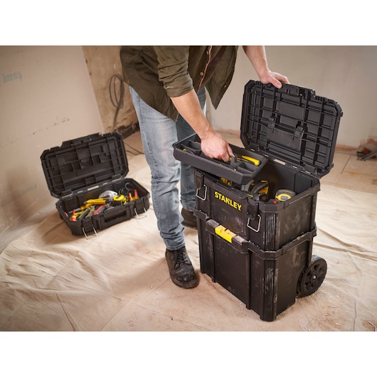 STANLEY STST83319-1 rolling toolbox with open lid, filled with tools, used in construction setting.