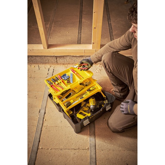STANLEY STST83397-1 tool box with yellow trays and assorted tools, photo of product in jobsite setting.