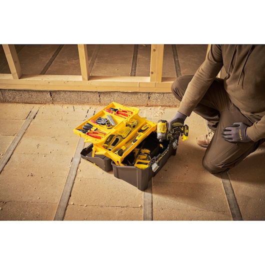 STANLEY STST83397-1 tool box open with assorted tools and drill in construction setting.